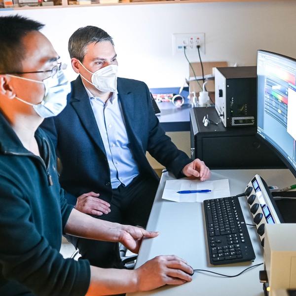 Senior author Dr. François Jean and co-author Dr. Guang Gao in front of a desktop computer at UBC LSI imaging facility 