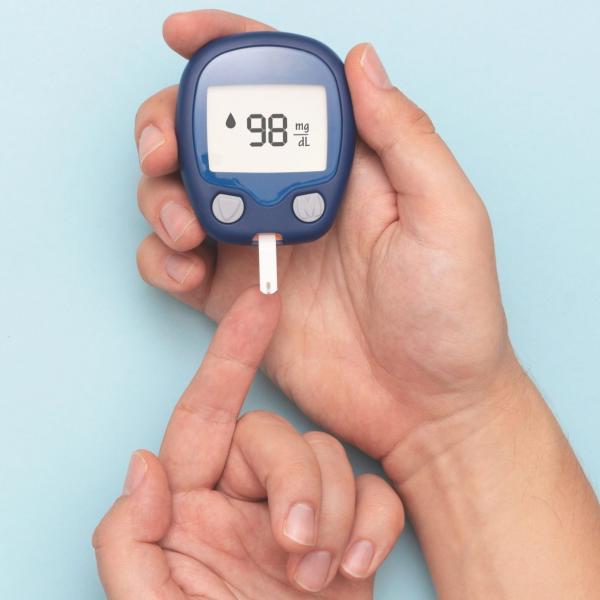 testing a finger with a blood glucose monitor